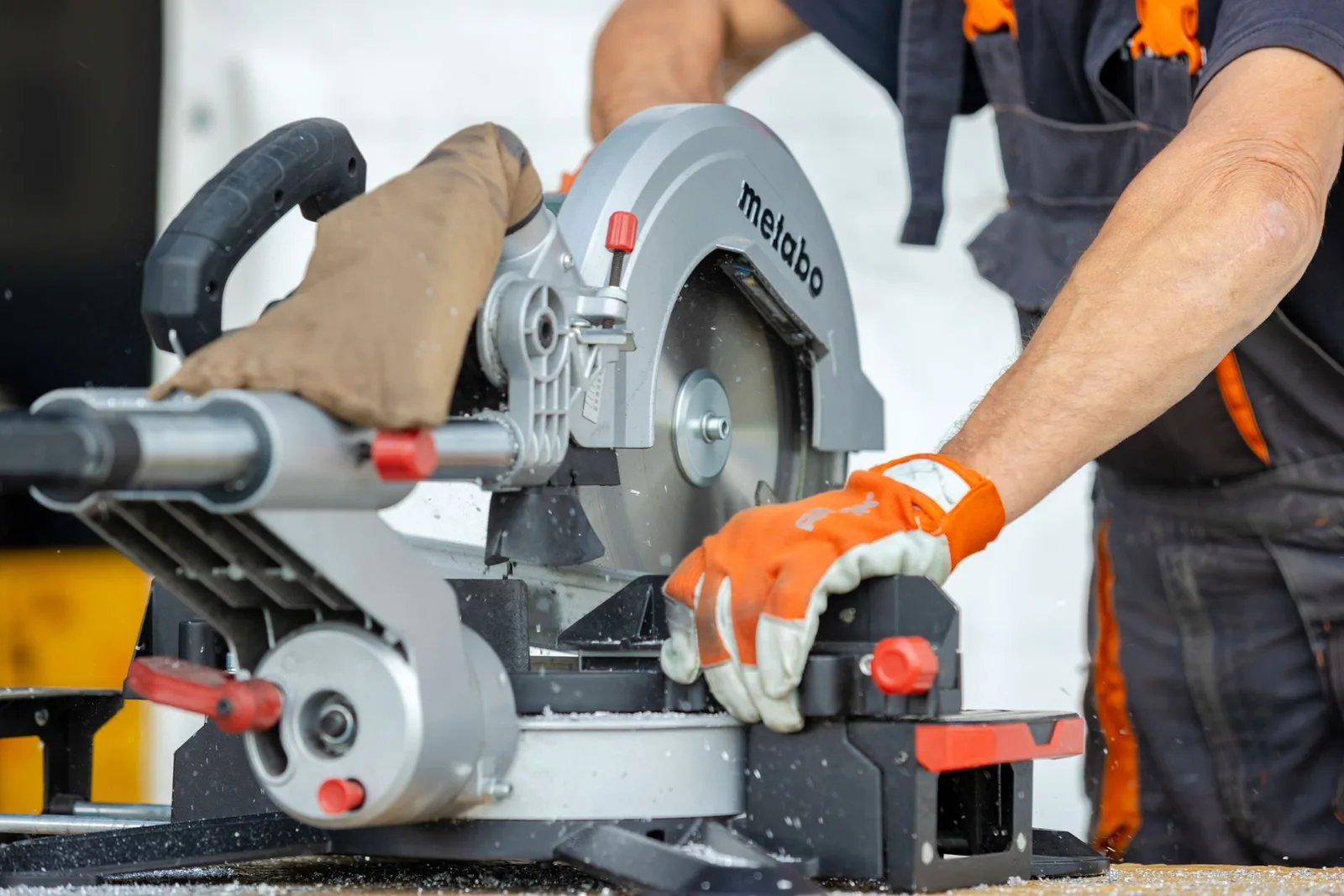 Close-up of a tradesperson using a circular saw on site